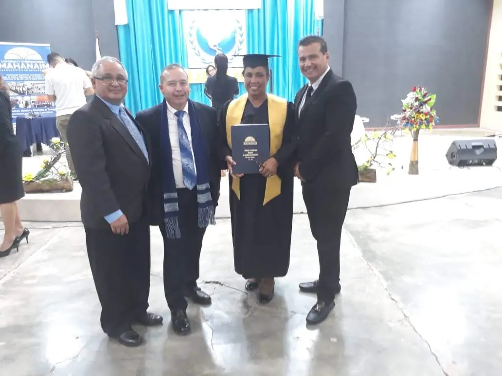 Graduado recibiendo su diploma junto a autoridades